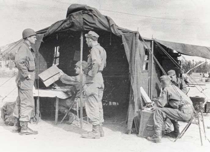 black white photo of 5 soldiers by a tent