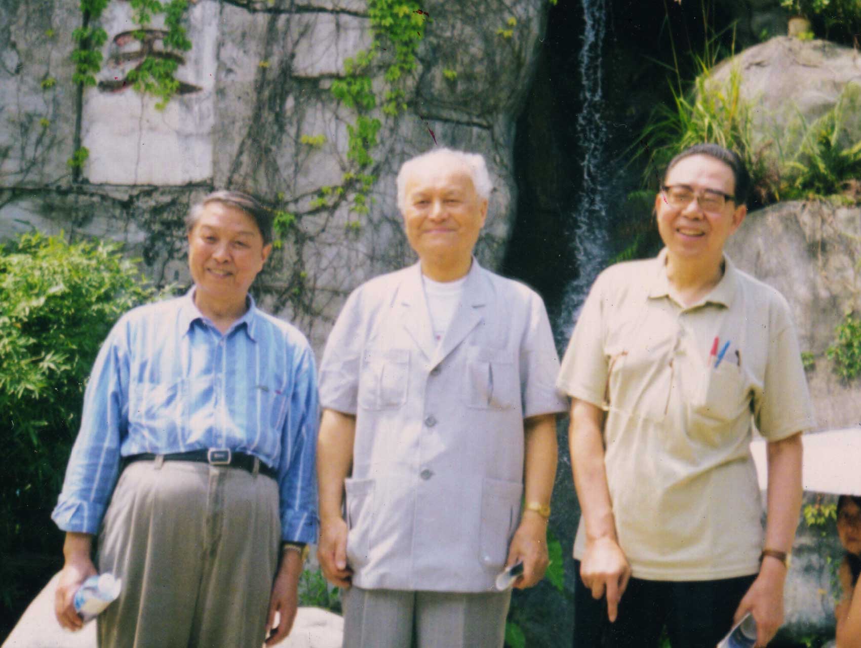 Three men standing in front of rock landscape 