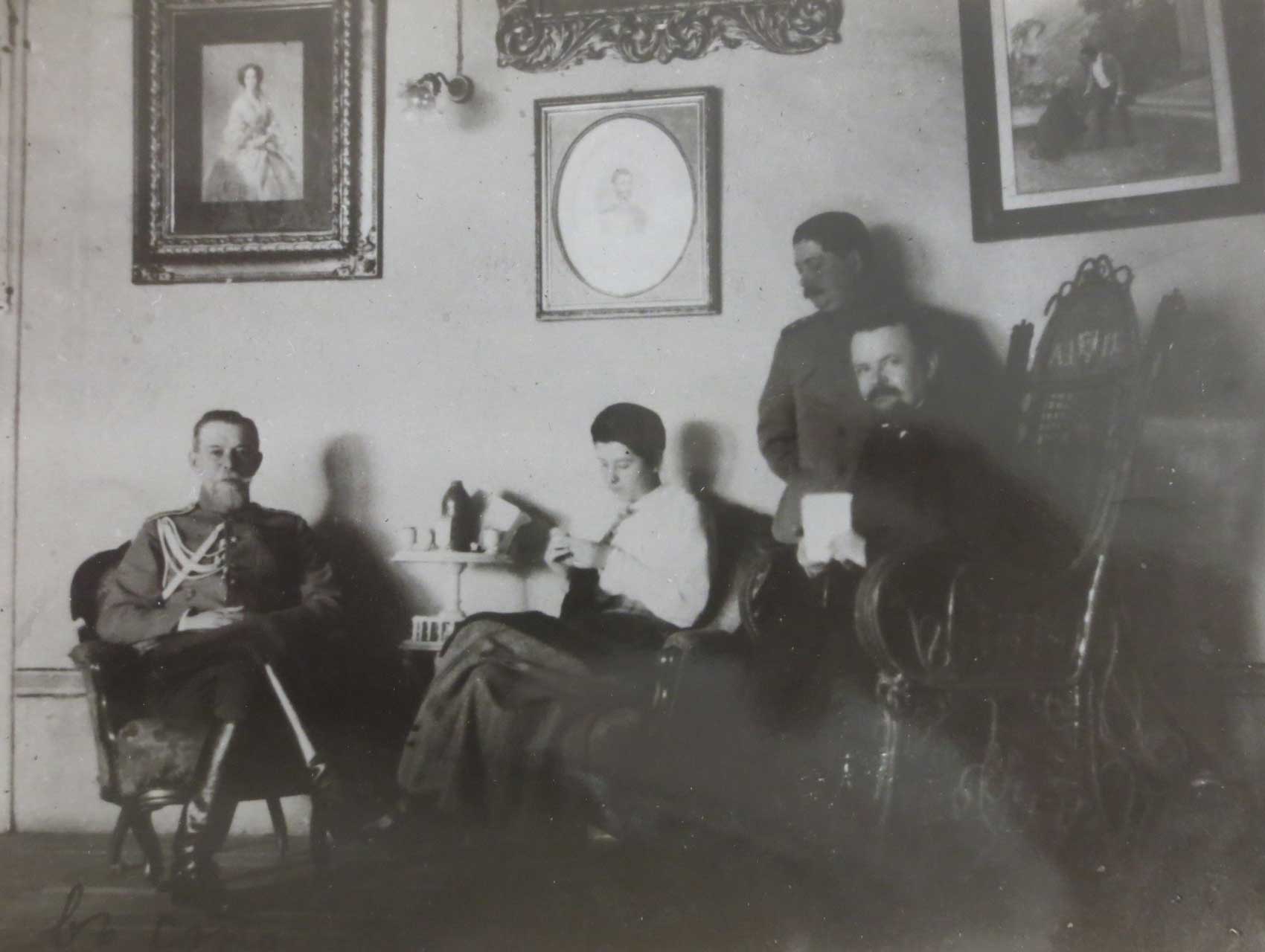 Black and white photo of people sitting in a room with artwork on the walls