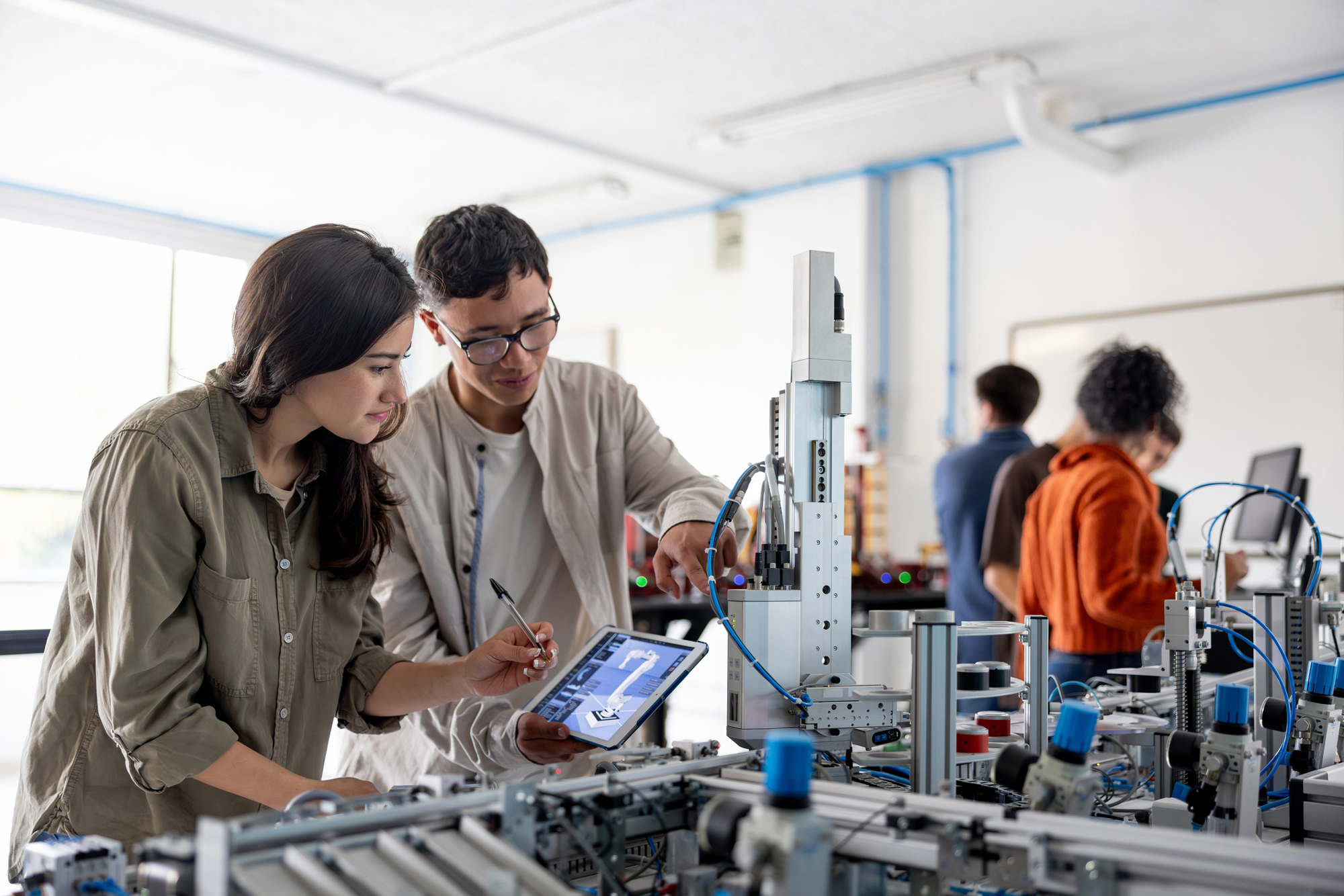 Team of students building a robotic arm in a STEM class stock photo
