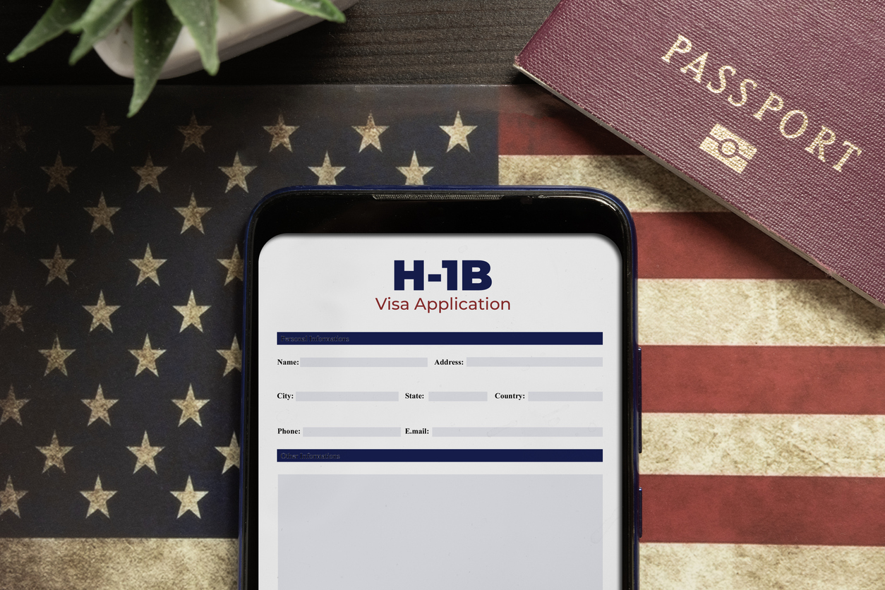 H-1b visa application concept: smartphone with USA H-1B visa application over a USA flag stock photo