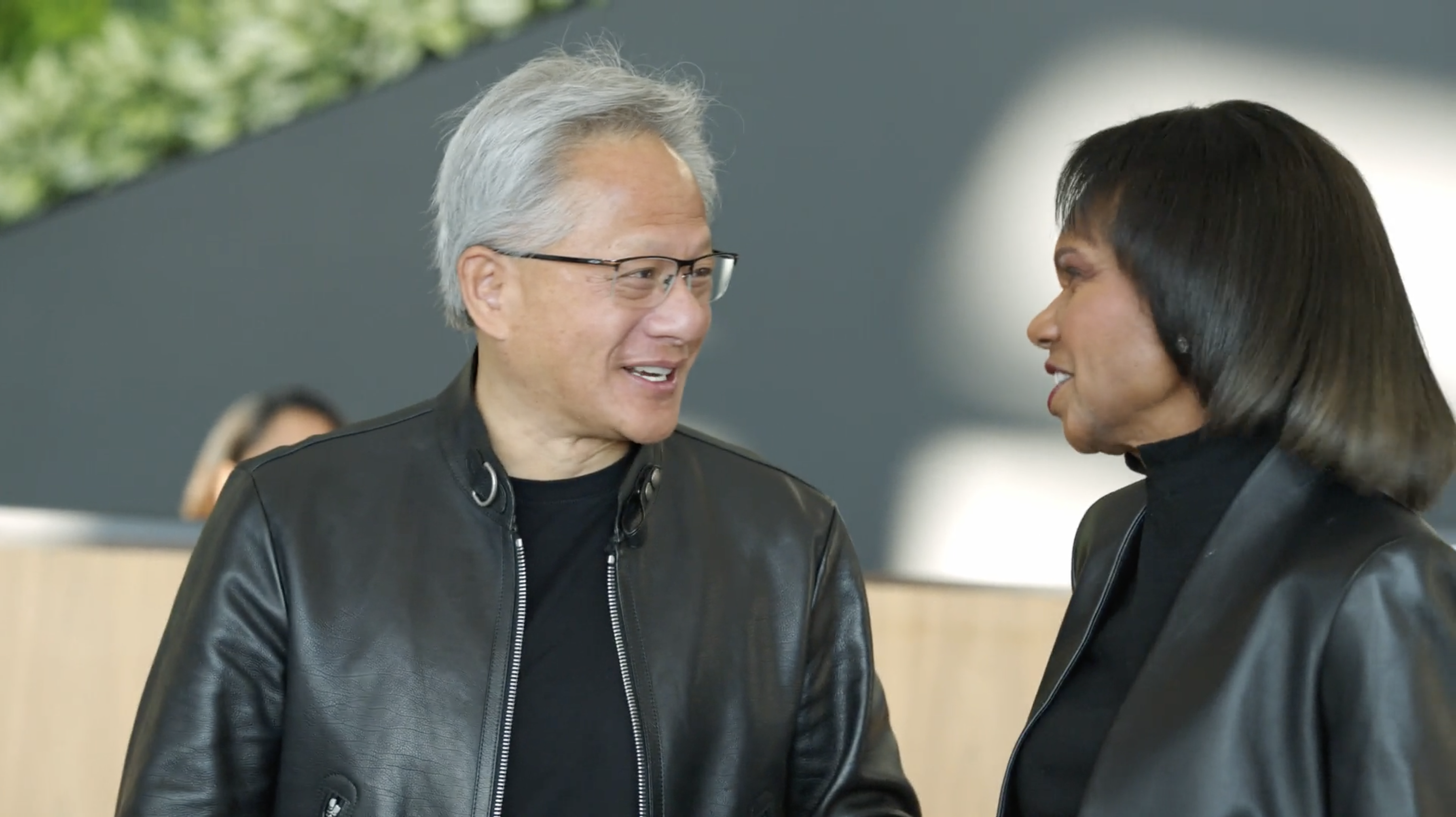 Jensen Huang speaks with Condoleezza Rice in the lobby of NVIDIA's Voyager building