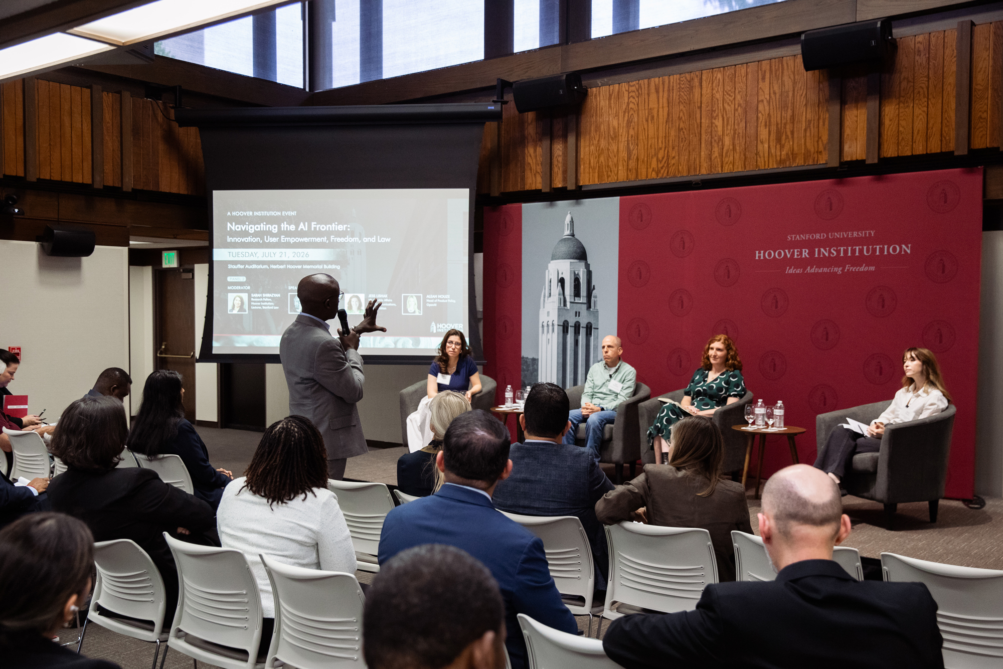 An attendee of the Navigating the AI Frontier event asks the panel a question on July 21, 2026, in Stauffer Auditorium. 