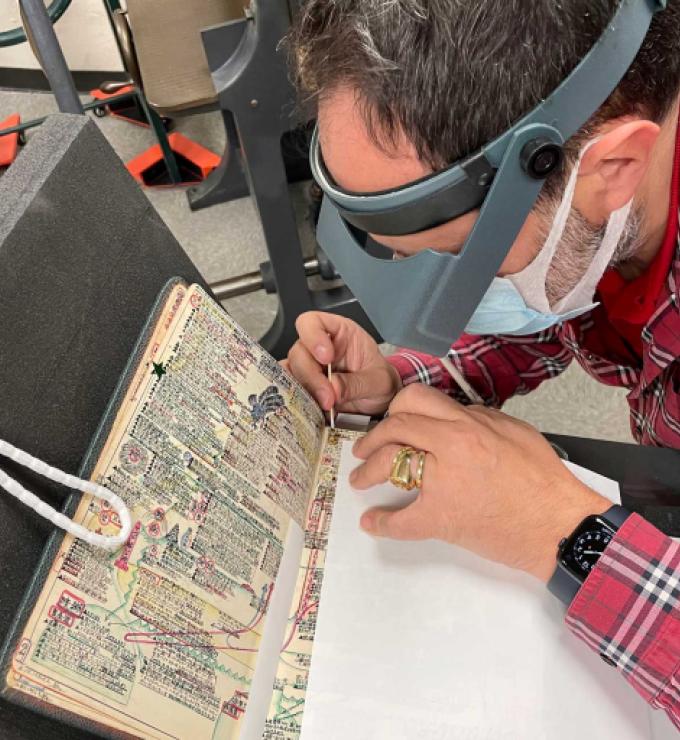 Laurent Cruveillier wearing magnifying goggle during conservation treatment of the Kitaji Bibles