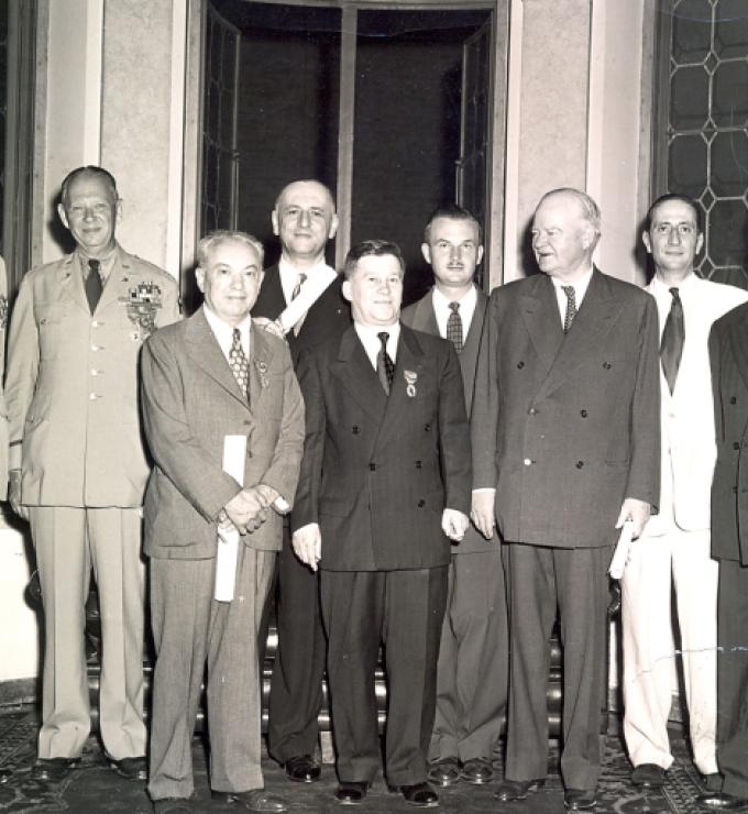 Group of men standing for a photo. Nicholas Feodoroff (front row center) with Herbert Hoover (front row right).