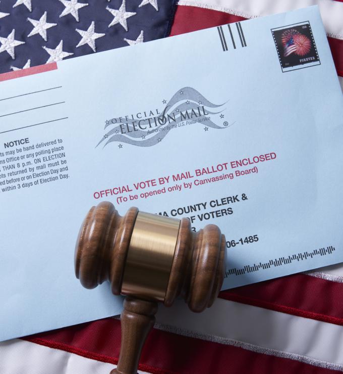 Voting ballot: Absentee voting by mail with ballot envelope on USA flag and gavel stock photo