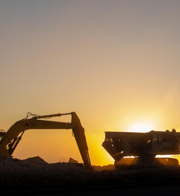 Construction machinery in the rays of the rising sun, early morning at the construction site stock photo