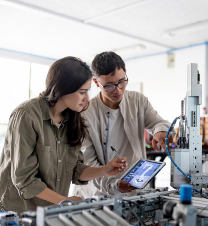 Team of students building a robotic arm in a STEM class stock photo