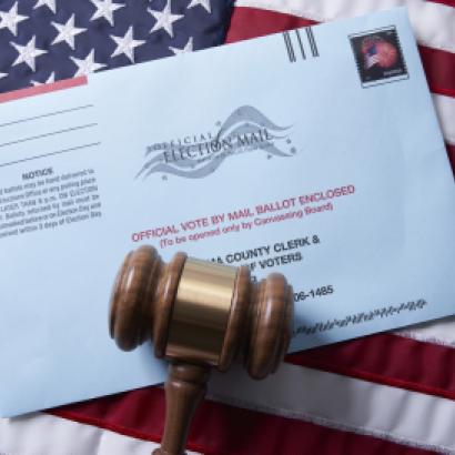 Voting ballot: Absentee voting by mail with ballot envelope on USA flag and gavel stock photo