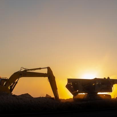 Construction machinery in the rays of the rising sun, early morning at the construction site stock photo