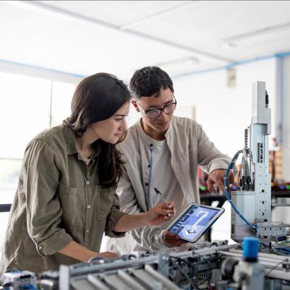Team of students building a robotic arm in a STEM class stock photo