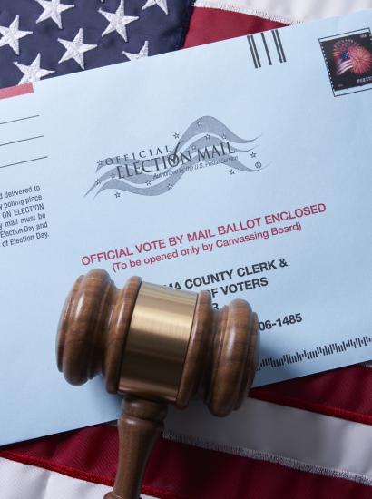 Voting ballot: Absentee voting by mail with ballot envelope on USA flag and gavel stock photo