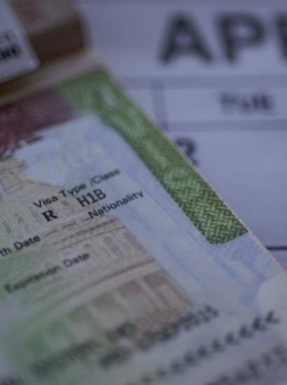 H1B visa (for specialty workers) stamp in passport, blurred april calendar on background. H1B visa program deadline concept. Close up view. stock photo