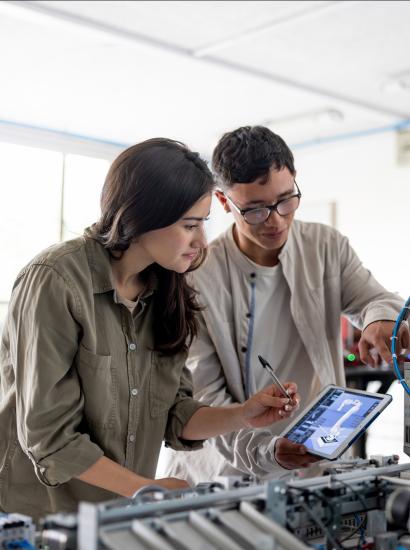 Team of students building a robotic arm in a STEM class stock photo