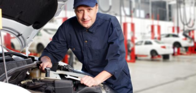 A white mechanic works on a car