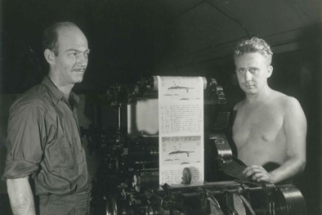 Two men operating a print press at the Office of War Information