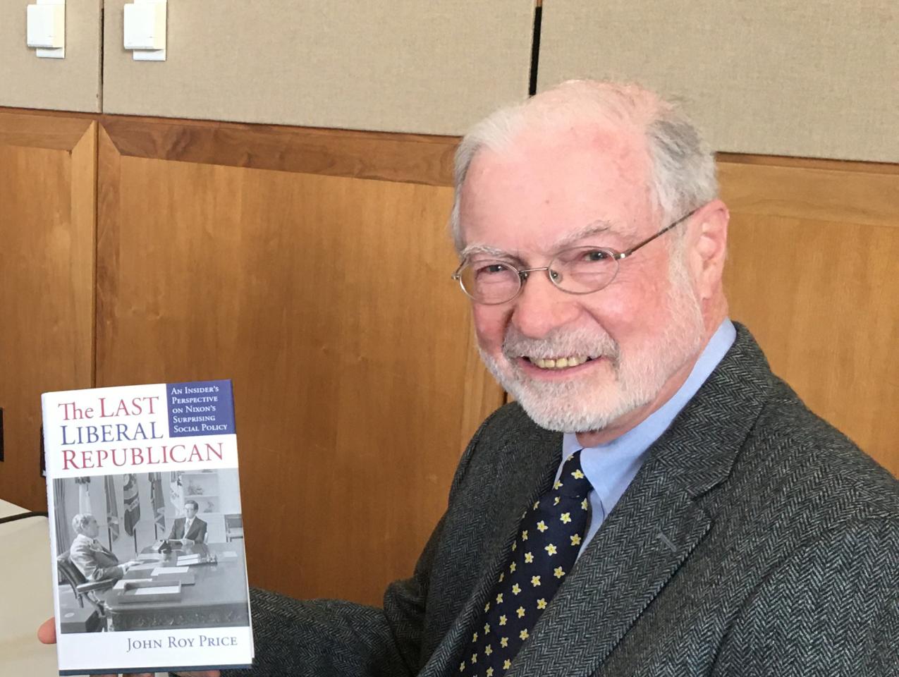 John Roy Price holding a copy of his book on President Nixon