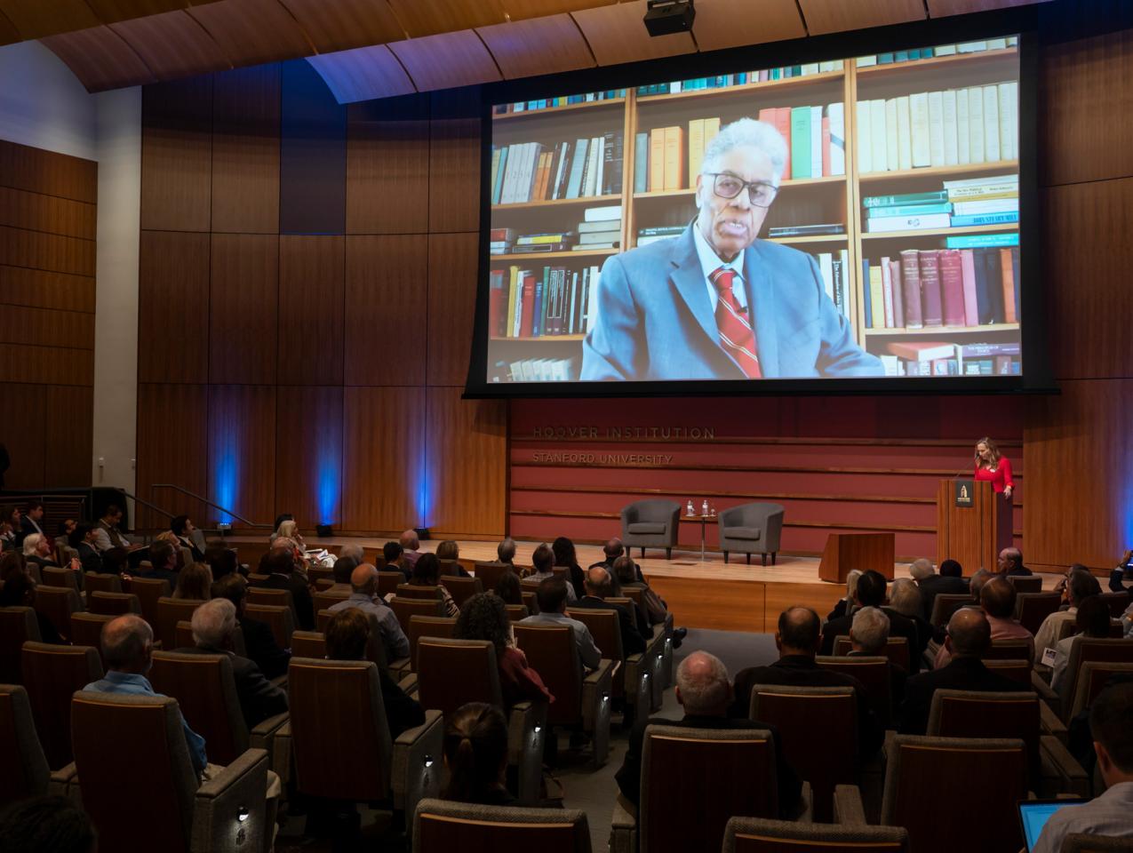 Thomas Sowell speaks on screen inside Hauck Auditorium at a celebration of his career on October 20, 2025. (Patrick Beaudouin)