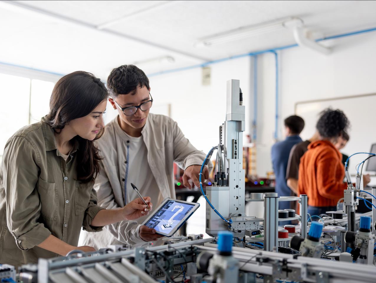 Team of students building a robotic arm in a STEM class stock photo