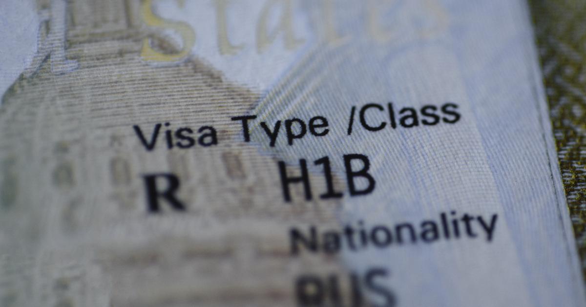 Fragment of H1B visa (for specialty workers) stamp in passport, blurred april calendar on background. H1B visa program deadline concept. Close up view. stock photo