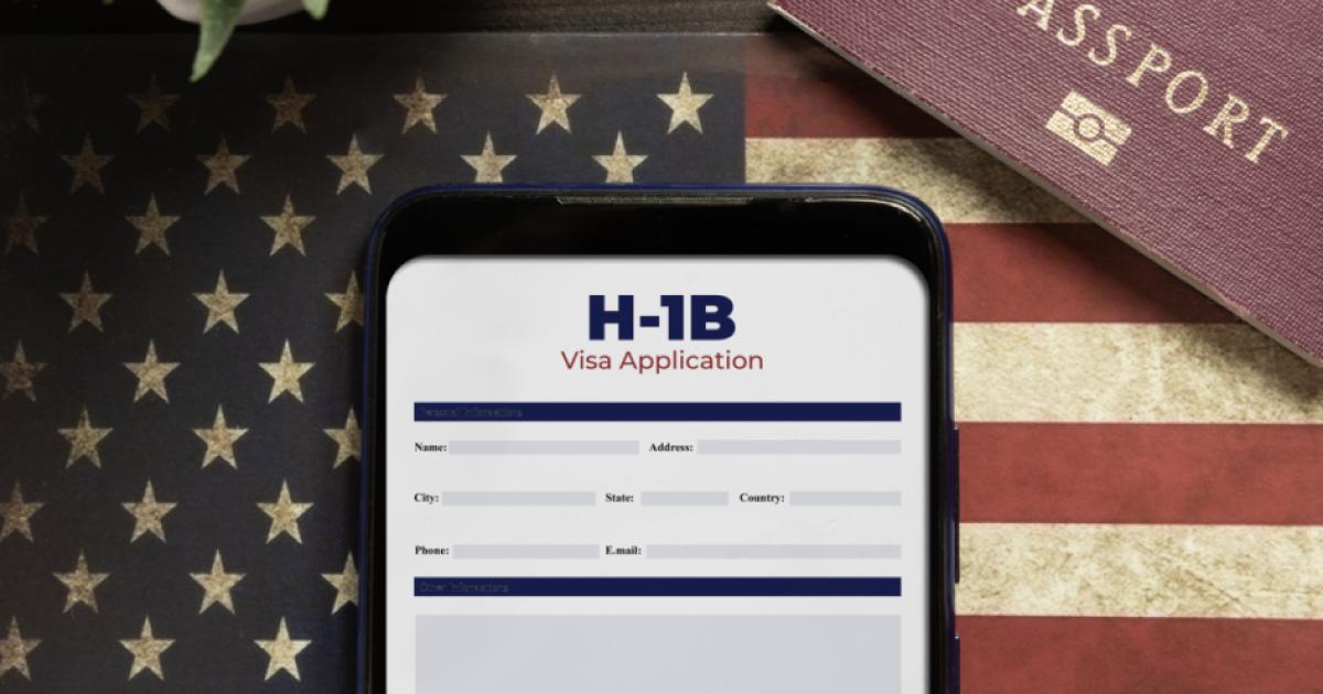 H-1b visa application concept: smartphone with USA H-1B visa application over a USA flag stock photo